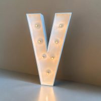 V - Letra de madera pintada en blanco con bombillas de decoración